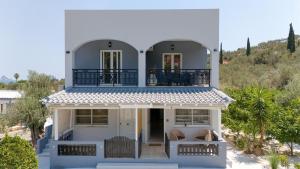 a white house with a balcony on top of it at Poetree Echo by Green Poetree Houses in Galatas