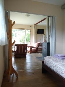 Un dormitorio con una cama y una sala de estar. en Una Morada en la Montaña, en El Bolsón