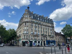 a large building on the corner of a street at Le Petit Nid - cozy comfort close to Paris in Clichy