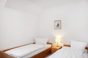 Dos camas en una habitación con paredes blancas. en Ferienwohnung Tannenblick 7-4, en Oberhof
