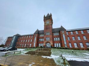 a large red brick building with a clock tower at Birch Hill Clock Tower in Rochdale