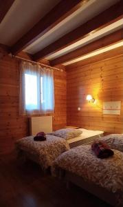 a bedroom with two beds and a window at Ecogite Mercantour Le Pacha in Valdeblore