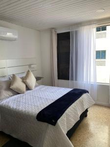 a bedroom with a large bed and a window at Acogedor Apartamento cerca al Mar in Cartagena de Indias