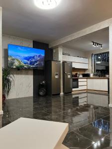 a kitchen with stainless steel refrigerators and a flat screen tv at Къща за гости Гардения in Kamburovo