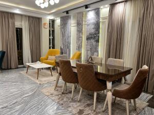开罗The Royal Apartment at New Cairo الشقة الملكية بالقاهره الجديدة的餐厅里有一张桌子和几把椅子