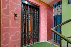 a black door in a pink wall with a staircase at Hotel O Star View in Kolkata