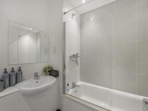 a white bathroom with a sink and a shower at Kent retreat - Book today and relax in Ashford +9 photos
