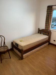 a bed in a room with a chair and a window at Departamento en Gualeguay in Gualeguay
