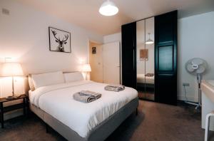 a bedroom with a bed with two towels on it at Prosper House Apartment 3 in Norwich