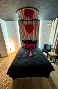 een slaapkamer met een zwart bed met rode harten erop bij Love room - Cap d'Agde in Cap d'Agde +5 foto's