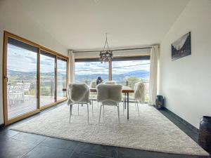 a dining room with a table and chairs and a large window at Villa d'excellence vue lac in La Salle-en-Beaumont