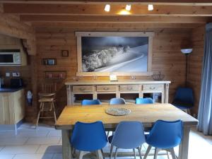 サン・モーリス・シュル・モセルにあるChalet des Brocardsの木製のテーブルと青い椅子のあるダイニングルーム