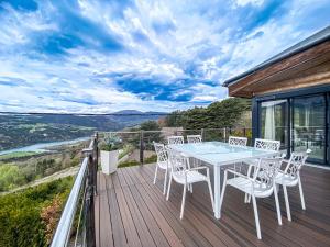 a table and chairs on a deck with a view at Villa d'excellence vue lac in La Salle-en-Beaumont