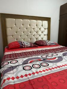 a bed with a red comforter and pillows on it at Apartamento #2 in Puerto Colombia
