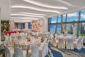 una sala banchetti con tavoli e sedie bianchi e finestre di The Park Lane Hong Kong, Autograph Collection a Hong Kong