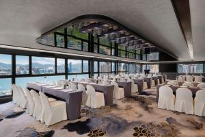 una sala banchetti con sedie e tavoli bianchi e finestre di The Park Lane Hong Kong, Autograph Collection a Hong Kong