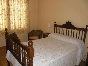 a bedroom with a wooden bed and a window at Casa Rural Baco in Baños de Valdearados