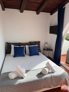a bedroom with a large bed with blue pillows at Vila Horizonte in Carvoeiro