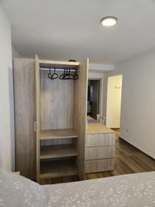 a bedroom with a bed and a wooden cabinet at Monumento y Río - Parking privado con costo adicional in Rosario