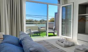 a bedroom with a bed and a large window at Nacar Apart Hotel in Santa Teresita