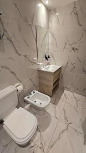 a white bathroom with a toilet and a sink at Monumento y Río - Parking privado con costo adicional in Rosario +19 photos