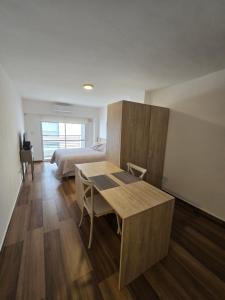 a room with a table and a bed and a bedroom at Monumento y Río - Parking privado con costo adicional in Rosario