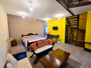 a bedroom with a bed and a couch and a table at Baibon3 Homestay Thalang Phuket in Ban Na Nai