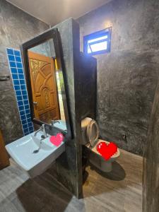 a bathroom with a toilet and a sink and a mirror at Baibon3 Homestay Thalang Phuket in Ban Na Nai