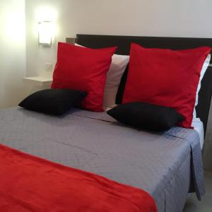 a bed with red and white pillows on it at Appartement Le Vieux Port in Marseille