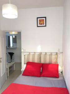 a bedroom with a bed with red pillows on it at Appartement Le Vieux Port in Marseille