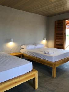 two beds sitting next to each other in a room at Casa Vento - 2 Andares e Cozinha in Luis Correia