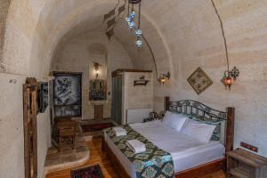 a bedroom with a bed in a stone room at Keyf i ala capadocia in Ürgüp