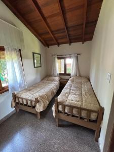 ein Schlafzimmer mit zwei Betten in einem Zimmer in der Unterkunft Makikihi - Barrio Norte in Villa Gesell + 7 Fotos