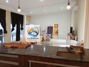 a kitchen and a living room with a counter top at La Balbina Casa Quinta Corrientes in Santa Ana