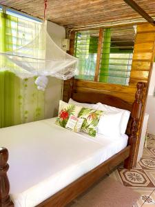 a bed in a room with a window at Le Petit Paradis in Roseau