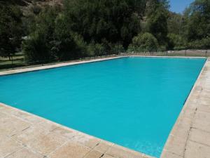 a large swimming pool with blue water at Cabañas Parque Almendro in San José de Maipo