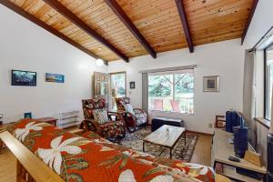 a bedroom with a bed and a living room at E Komo Mai Retreat Ohana in Volcano