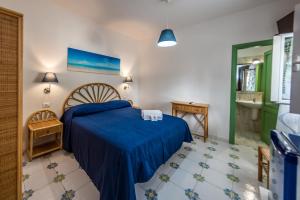 a bedroom with a blue bed and a bathroom at Ischia Dream Sunset in Ischia