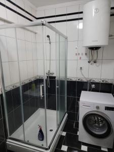 a shower in a bathroom with a washing machine at Apartman Aylin in Tuzla +12 photos