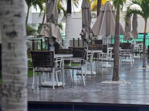 a group of tables and chairs with umbrellas at Luxor Paulo Miranda Cabo Branco by Hosppedar in João Pessoa