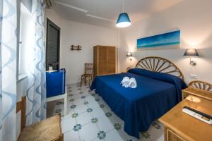 a bedroom with a blue bed with shoes on it at Ischia Dream Sunset in Ischia