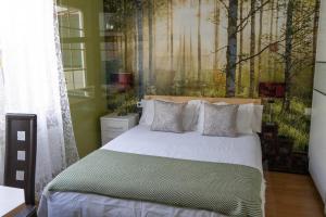 sypialnia z łóżkiem z drzewami na ścianie w obiekcie EARRA - Villa Eki - 2 garajes, playa a 7 min a pie w mieście Zarautz