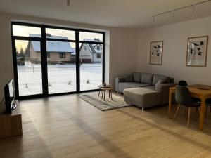 a living room with a couch and a table at Apartamenty pod sosną in Zakrzewo