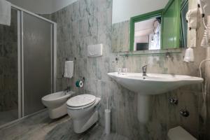 a bathroom with a sink and a toilet and a mirror at Ischia Dream Sunset in Ischia