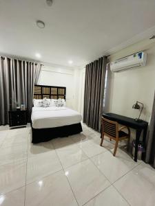 Un dormitorio con una cama, un escritorio y un piano. en RDA 2 bedroom at Spintex, en Accra