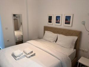 a bedroom with a bed with two towels on it at Small budjet deluxe studio down town in Thessaloniki +2 photos