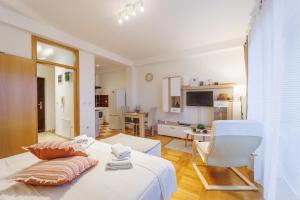 a bedroom with a bed and a living room at Studio apartman The SPOT in Osijek