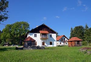 a large white house with a wooden roof at Helles Landhaus auf Waldlichtung in Dießen am Ammersee
