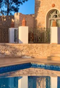 a house with a swimming pool and a fence at Le Domaine d'Eden - Villa luxueuse, piscine, spa et personnel in Essaouira