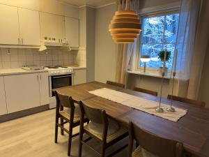 a kitchen with a wooden table with chairs and a window at 2 Bedroom apartment close to Branäs Resort - Likemovägen 12B in Likenäs
